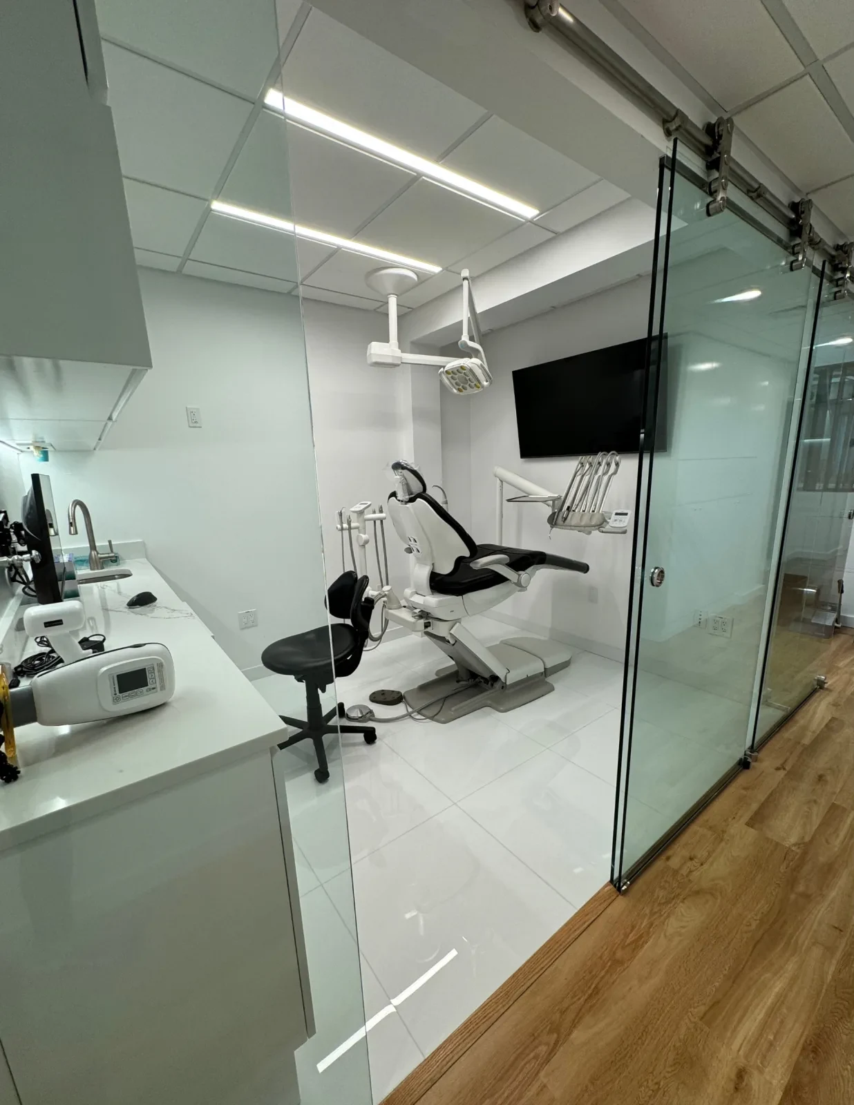 A treatment room at LAL Dental, with the chair, overhead light and wall-mounted screen