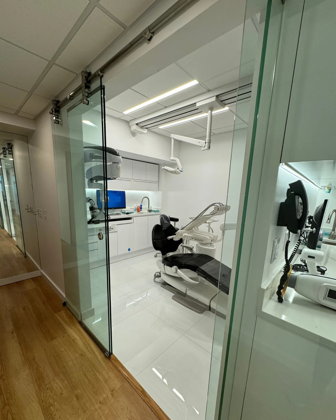 A second treatment room at LAL Dental, seen from the corridor through a glass wall